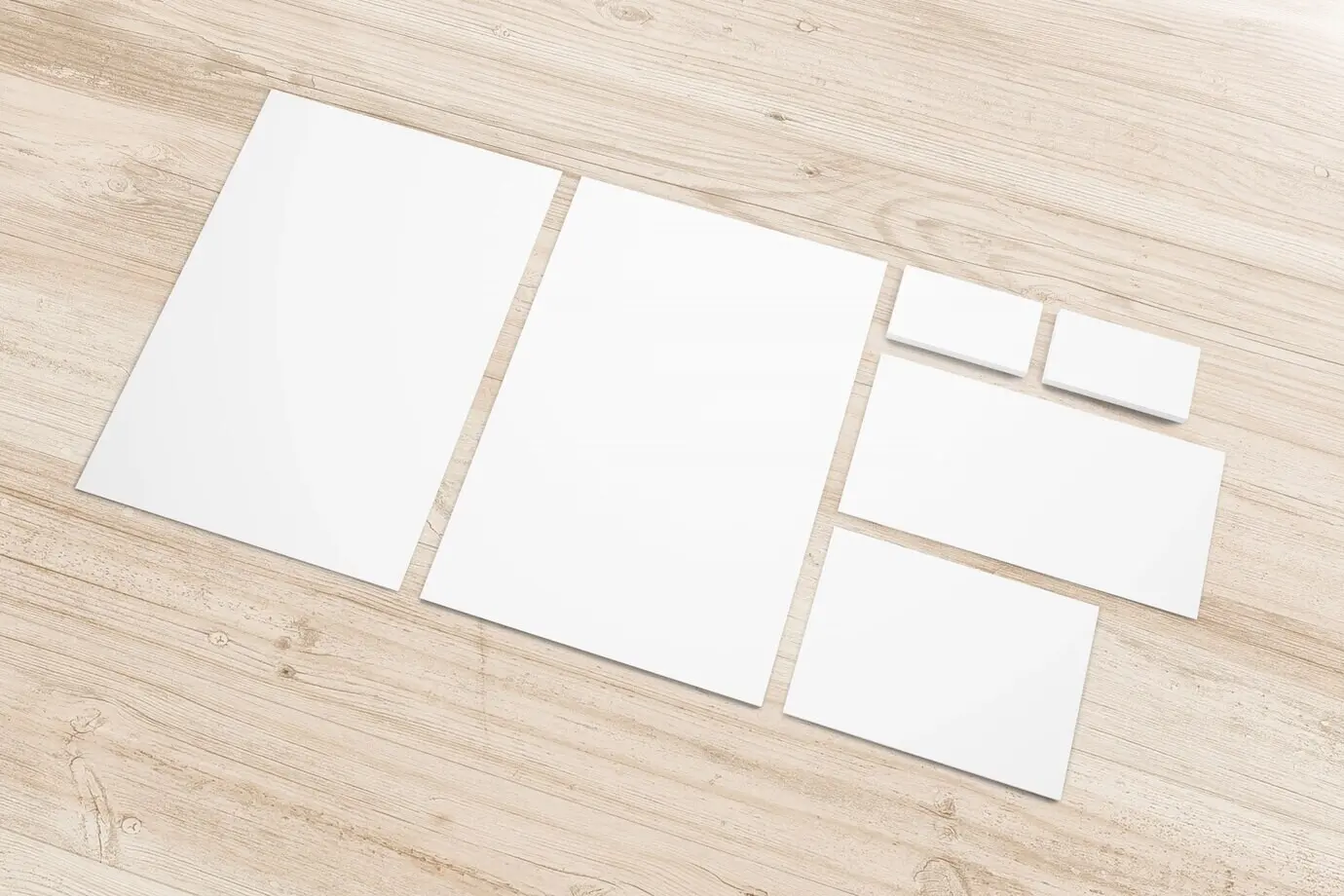 Набор канцелярии из чистой бумаги на деревянном письменном столе.